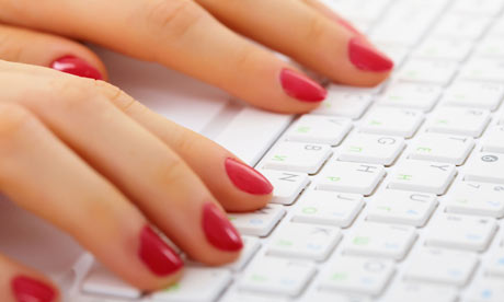 A woman typing on a computer keyboard